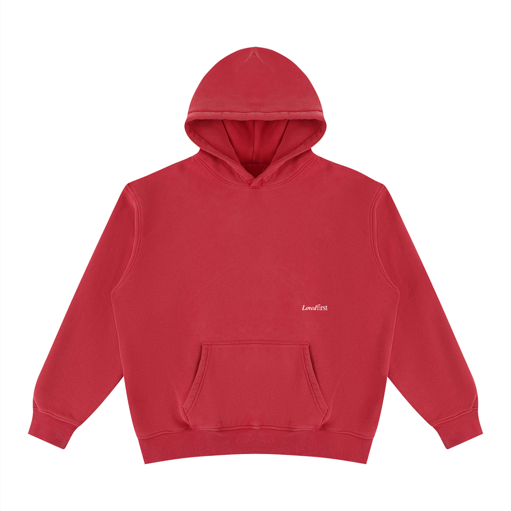 A red pullover hoodie with a kangaroo pocket and a small white 'LovedFirst' logo printed on the left chest, displayed on a clean white background.