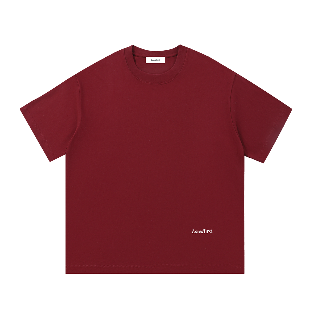 A Wine Red crewneck t-shirt with a small white 'Lovedfirst' logo printed on the bottom right, displayed flat against a solid white background.